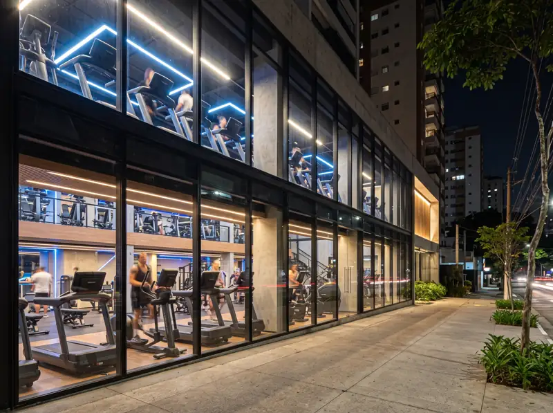 Fachada iluminada de uma academia da Rede Pulso à noite